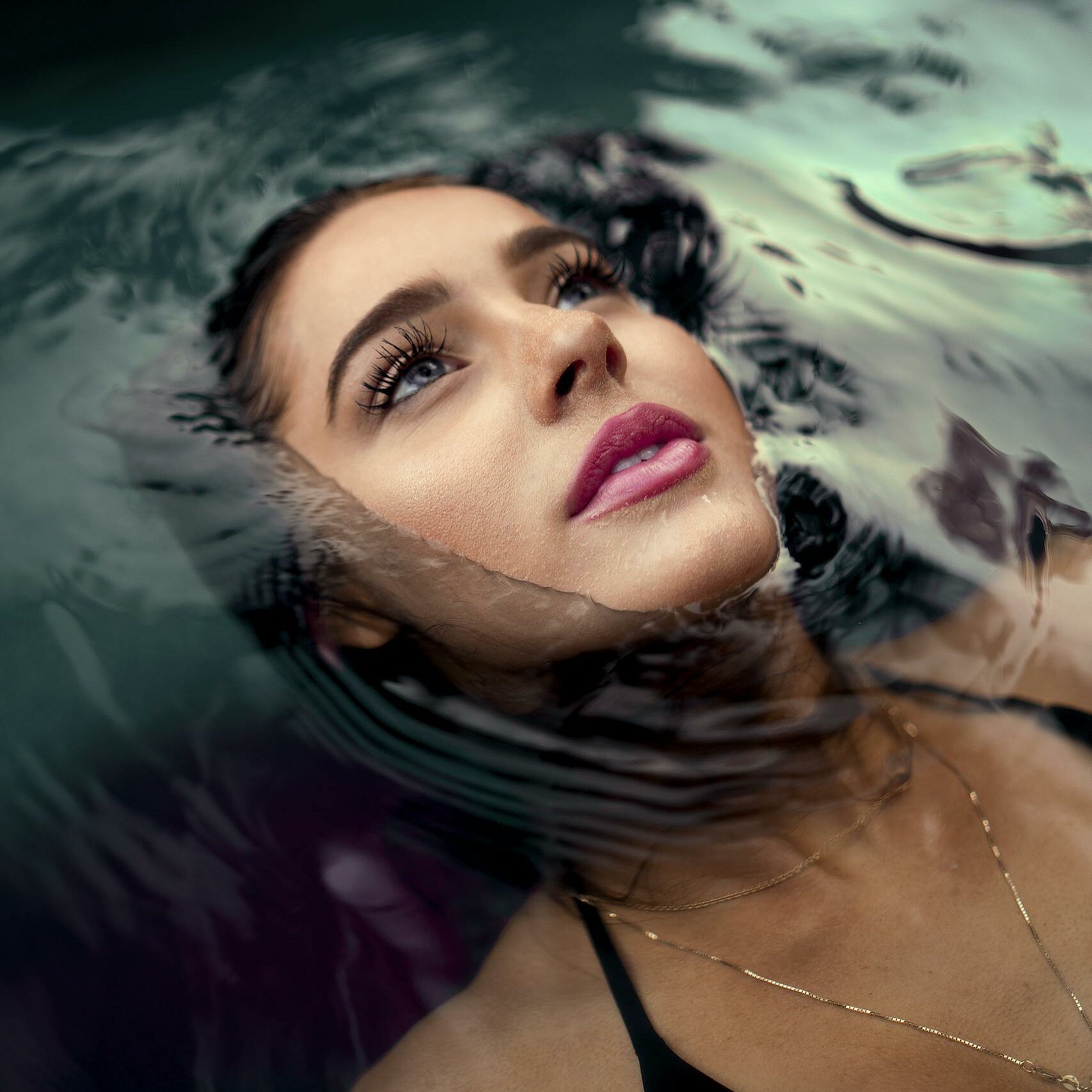 Portrait of a Woman Wearing Makeup Lying Down on Water