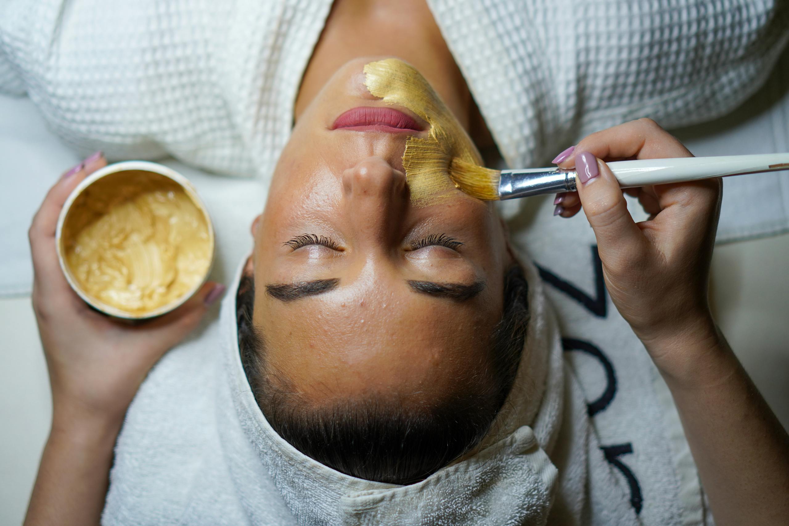 Femme recevant un traitement de Peeling avec pinceau doré